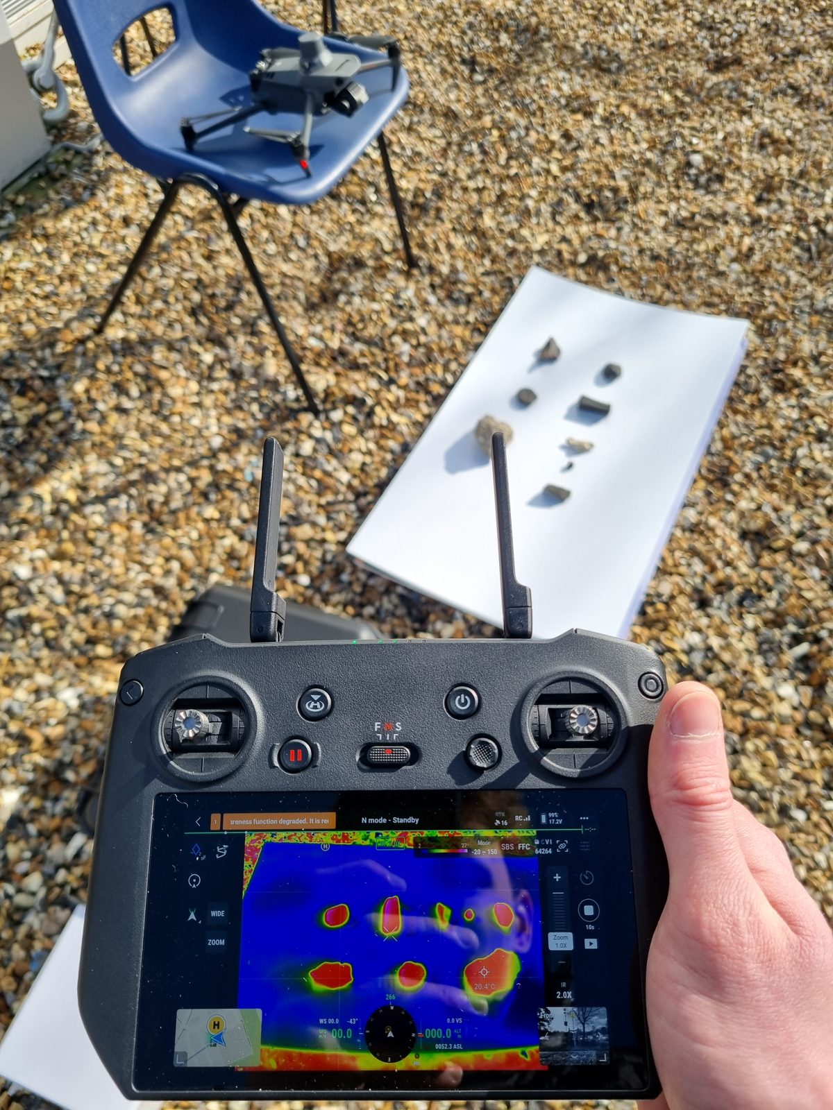 Thermal imaging view of rock samples during meteorite-recovery fieldwork, with drone and controller